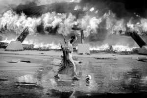 Philippe de Poulpiquet photograph: a rebel fighter kicks a football beside the burning Bab al-Aziziya compound, Tripoli, 2011